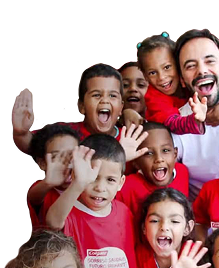 Een groep glimlachende kinderen die zwaaien, gekleed in rode Colgate-T-shirts, naast een glimlachende man in een wit overhemd