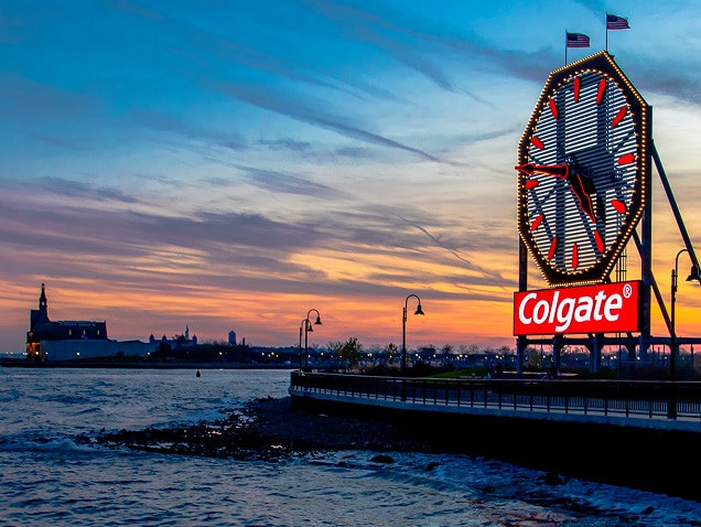 zeekust, met op de achtergrond het Colgate-logo onder een grote klok met rode wijzers